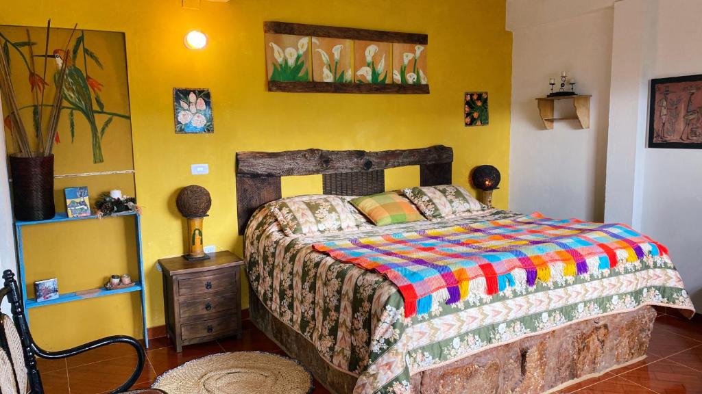 um quarto com uma cama com um edredão colorido em Finca Renacer em Tibaná
