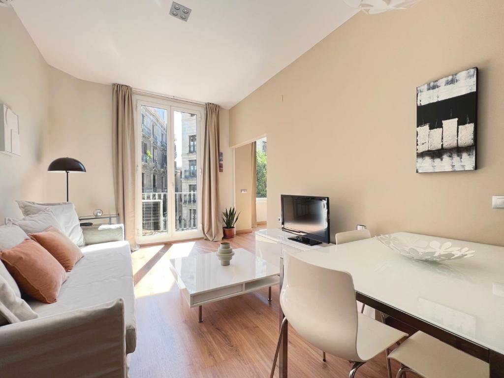 バルセロナにあるStay U-nique Apartments Fontanellaのリビングルーム(白いソファ、テーブル付)