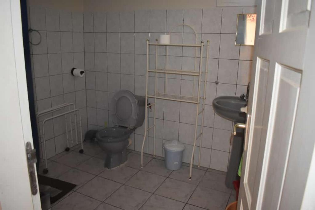 a bathroom with a toilet and a sink at L'orangespaîce à 5 minutes des plages in Sainte-Anne