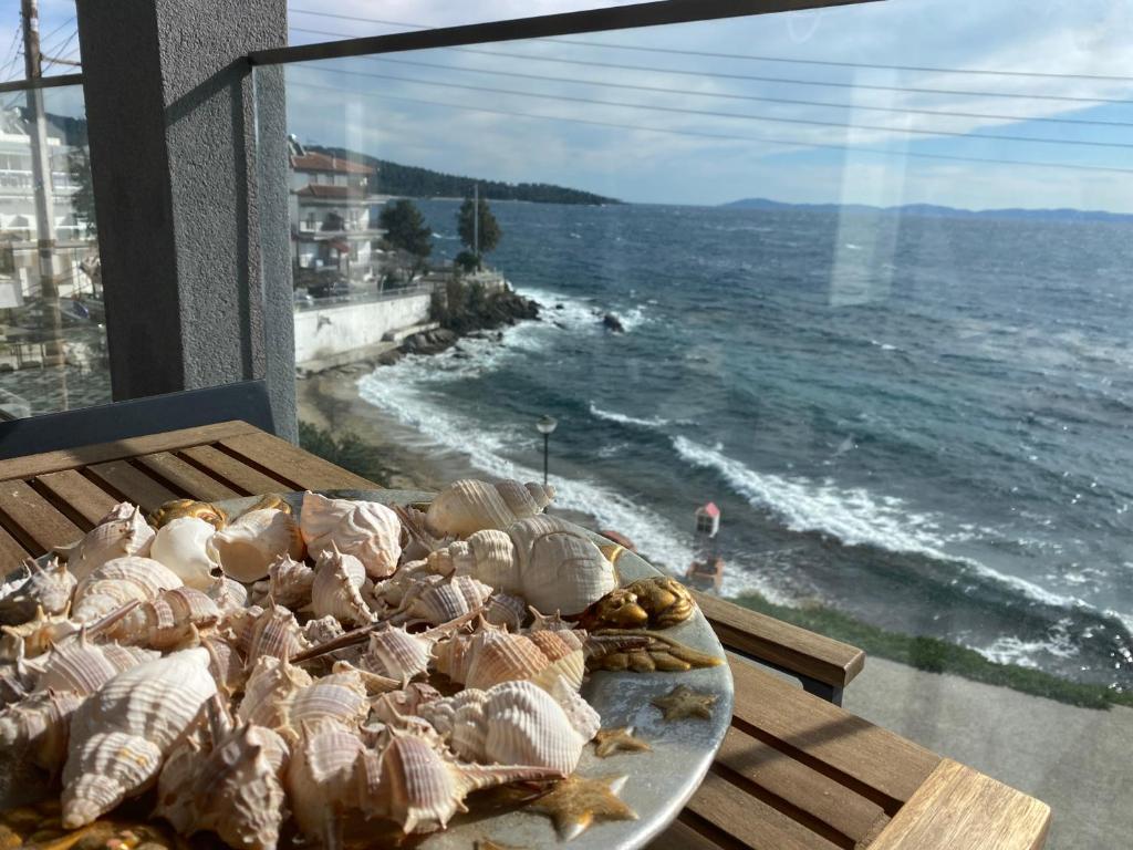 a plate of shells on a table with a view of the ocean at Candi Luxury Suites in Neos Marmaras