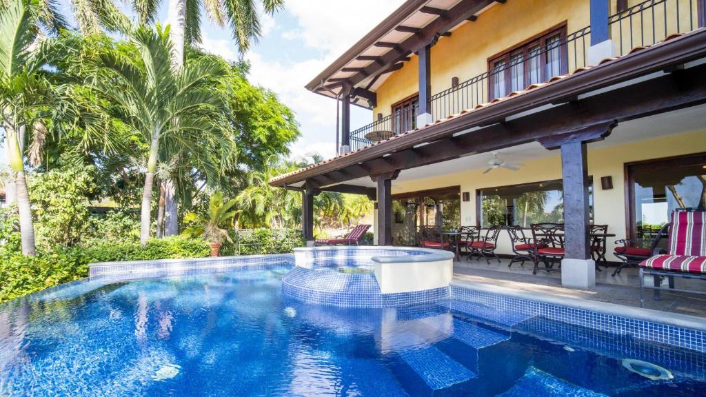 una piscina frente a una casa con palmeras en Villa Zindagi Luxury Villa Private Pool - Reserva Conchal en Brasilito