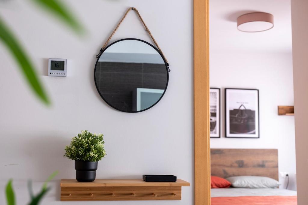 a mirror hanging on a wall in a bedroom at Apartamentos Vernia in Xàtiva