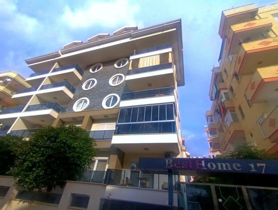Um edifício alto com um sinal azul à frente. em Very close to Cleopatra beach. em Alanya
