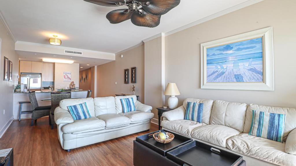 sala de estar con 2 sofás blancos y ventilador de techo en Sea Breeze 305, en Biloxi