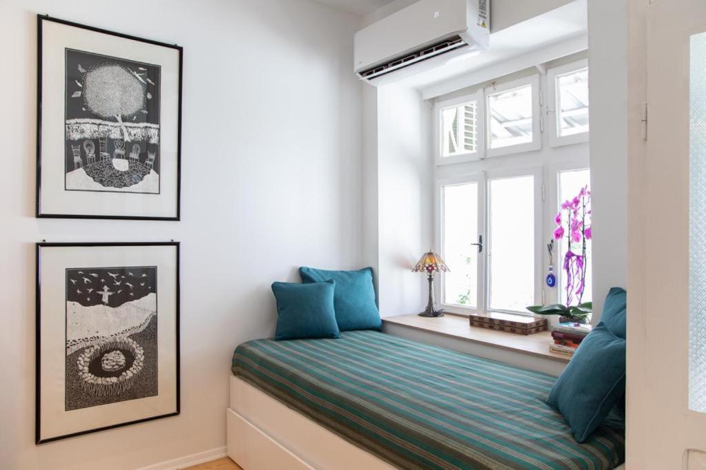 1 dormitorio con asiento junto a la ventana y almohadas azules en Ohrid Center Galerie House, en Ohrid