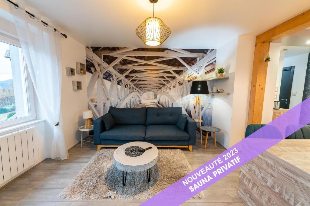 a living room with a blue couch and a table at Gîte l'Améthyste 3 appartements in Gérardmer
