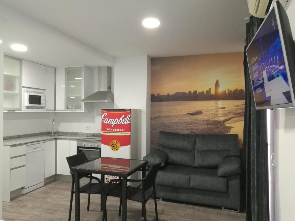 Hotel Estudio-ático en casco antiguo, a kitchen with a couch and a table in a room at Estudio-ático en casco antiguo in Benidorm