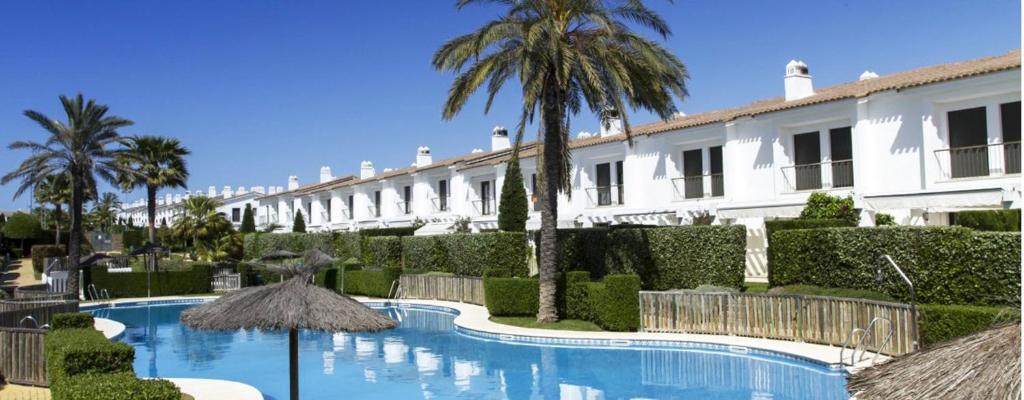 Un complejo con piscina y un edificio. en Exclusivo Adosado en Punta Coral El Rompido, en El Rompido