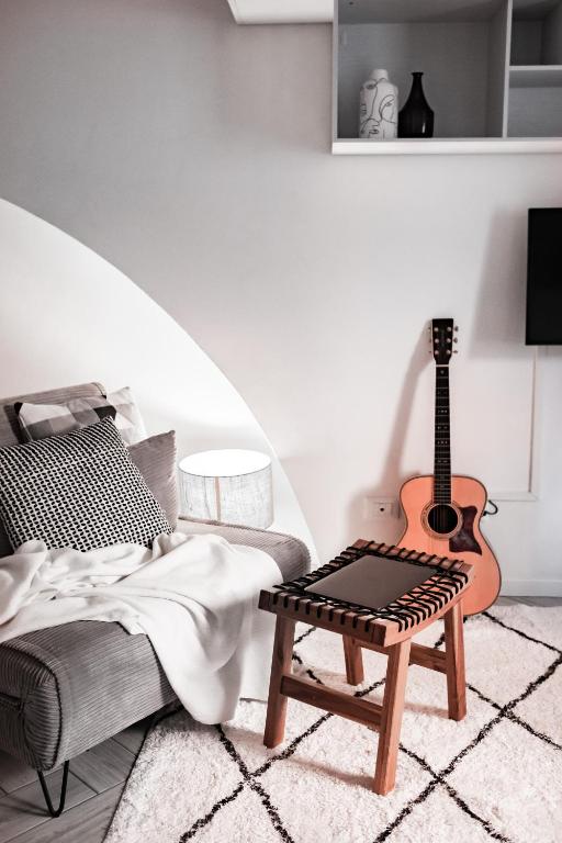 a living room with a guitar and a chair at [Ferrara Centro - SABI APT] in Ferrara