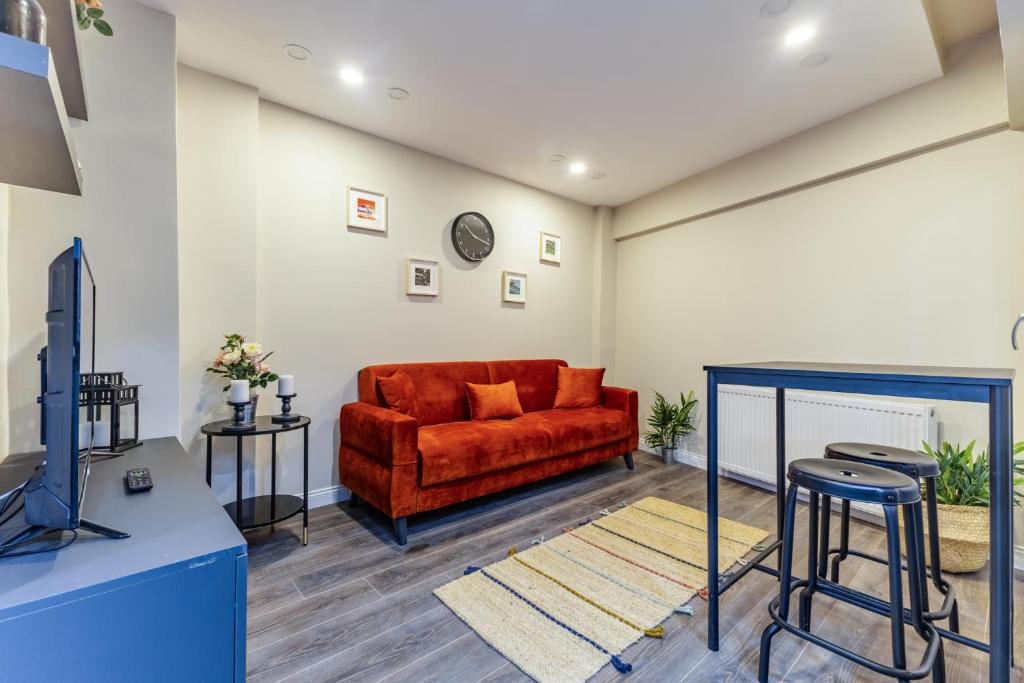 a living room with a red couch and a tv at rnished M in Istanbul