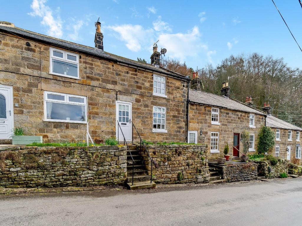 una vieja casa de piedra a un lado de la carretera en Esk Dale View, en Grosmont