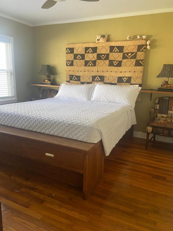 een slaapkamer met een groot bed met een houten hoofdeinde bij Cozy comfortable PRIVATE BEDROOMS in Atlanta