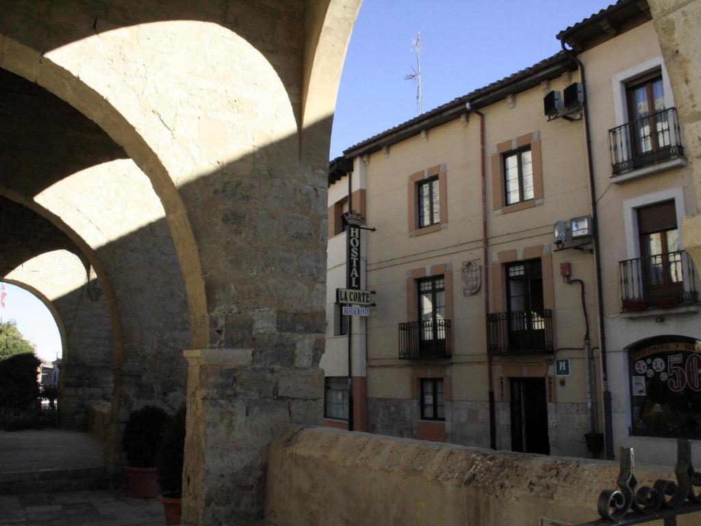 un edificio con un arco di fronte a una strada di Hostal La Corte a Carrión de los Condes