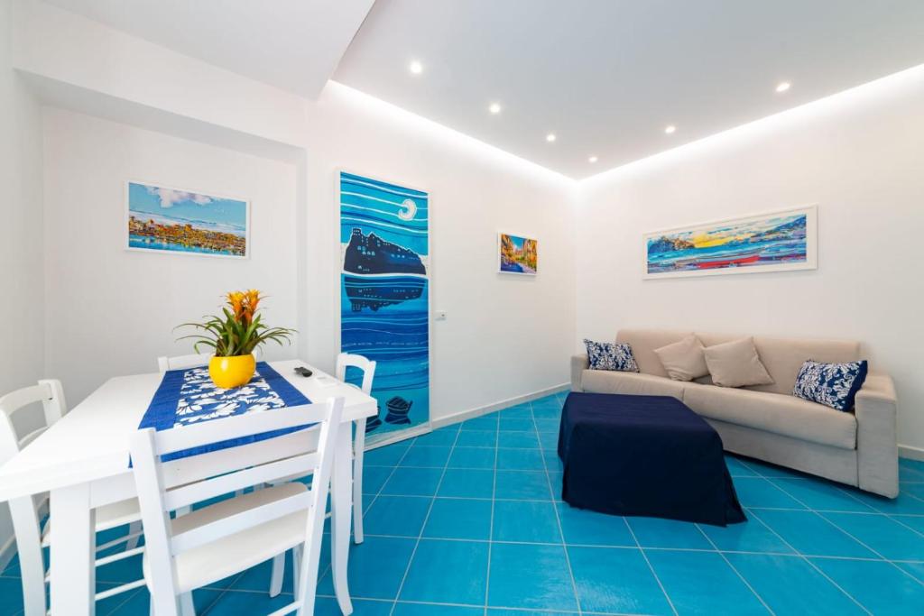 Una sala de estar con una mesa blanca y un sofá. en A due passi dal mare Gelso, en Isquia