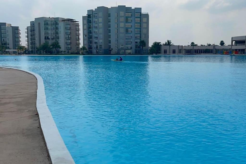 uma grande piscina de água azul com edifícios ao fundo em El Rincón Veracruz, Dream Lagoons em Veracruz