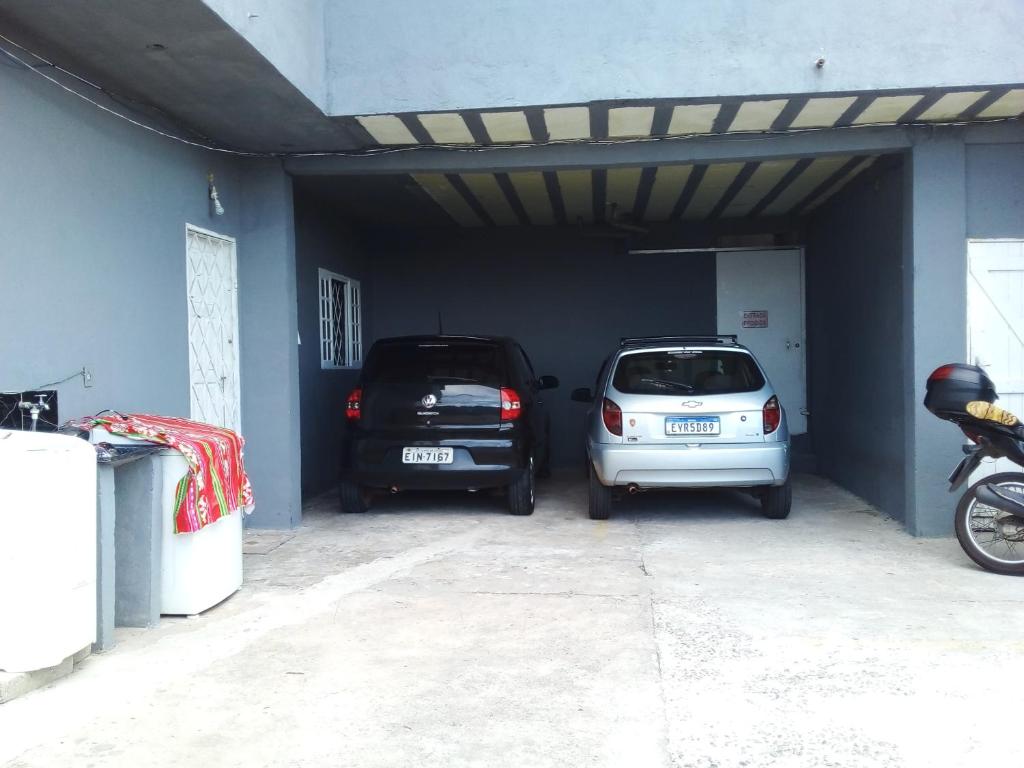 Dos autos están estacionados en un garaje. en Cantinho da paz, en Campos do Jordão