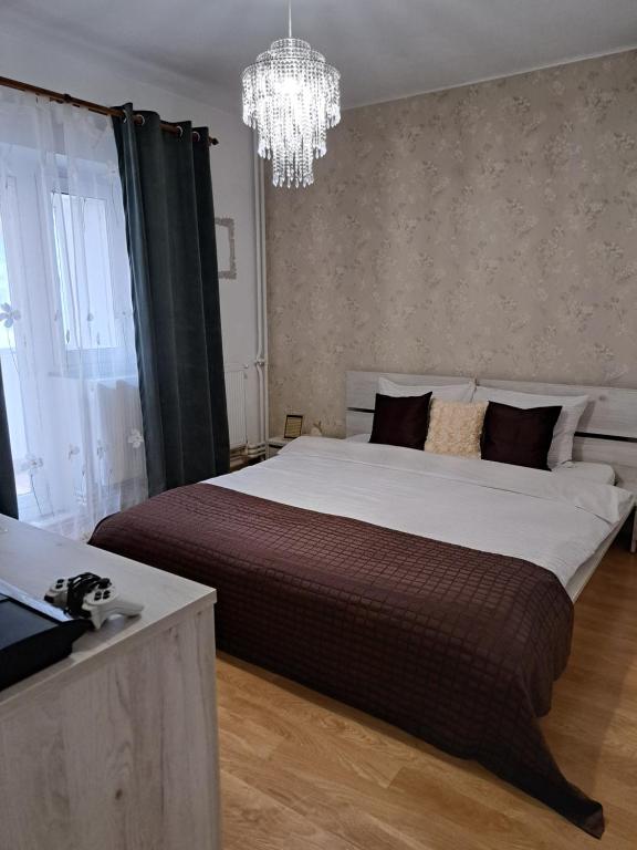um quarto com uma cama grande e um lustre em Relax Apartament em Constança