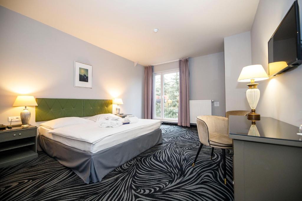 Postel nebo postele na pokoji v ubytování Parkhotel Carlsbad Inn