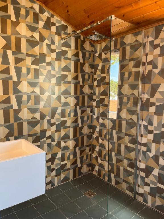 a bathroom with a tiled wall with a shower at Villa Usignolo in Lignano Sabbiadoro