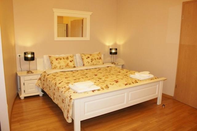 a bedroom with a white bed with two lamps on it at City Inn Residence in Timişoara