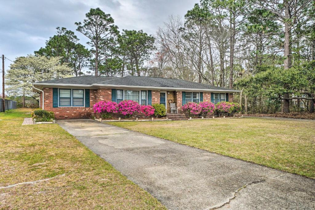 a brick house with pink flowers in a yard at Cozy Wilmington Vacation Rental 10 Mi to Beach! in Wilmington