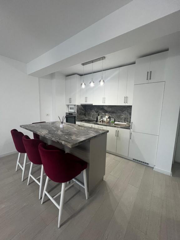 a kitchen with a large table and red chairs at Panorama 901 in Oradea