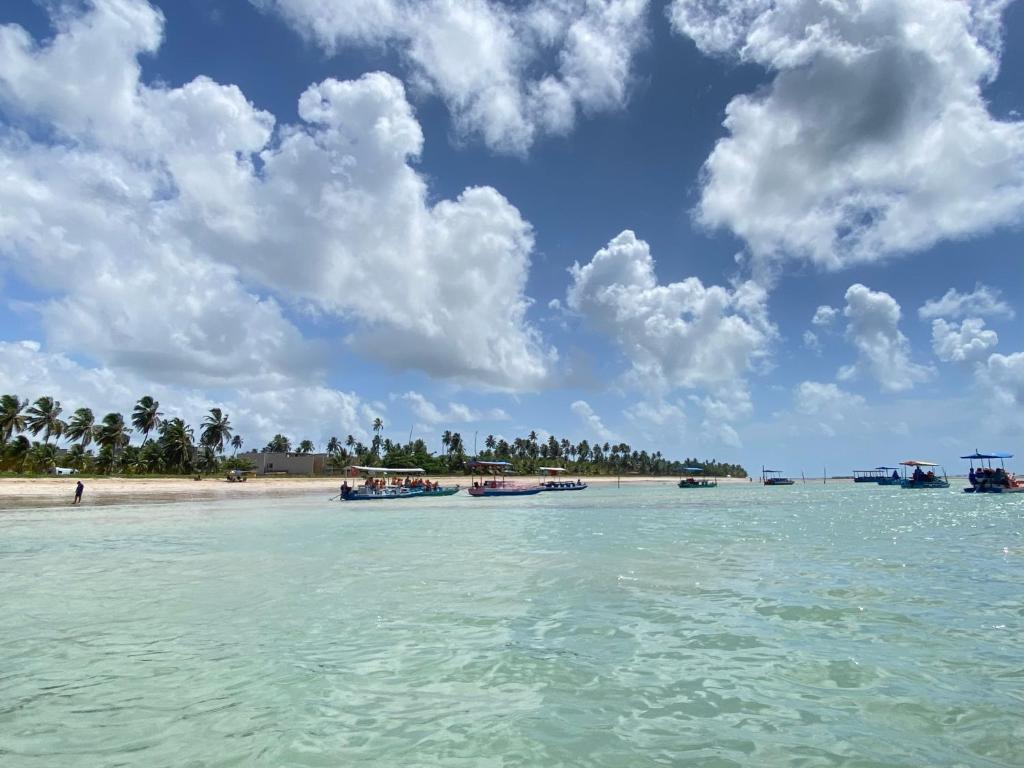 a group of boats in the water on a beach at Casa de Dora in São Miguel dos Milagres