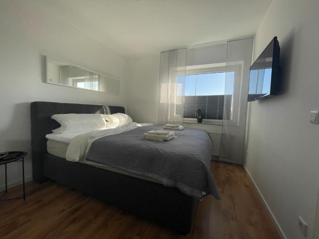 a bedroom with a large bed with a window at FeWo an der Nordseeküste mit Garage in Wilhelmshaven