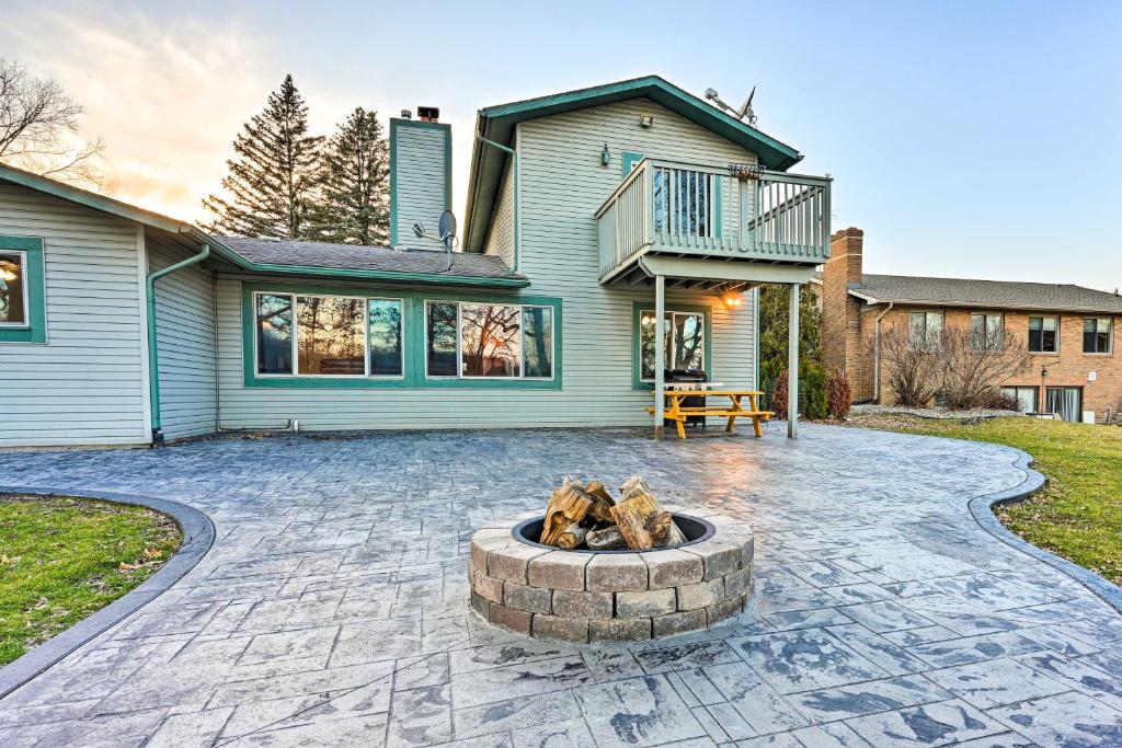 a patio with a fire pit in front of a house at Lakefront Hartland Cottage with Patio and Fire Pits! in Hartland
