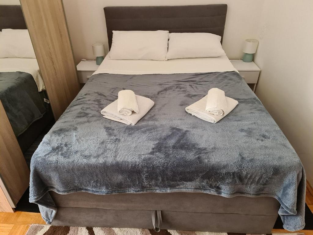 a bedroom with a bed with two white towels on it at Apartman u Velikoj Gorici Željko in Velika Gorica