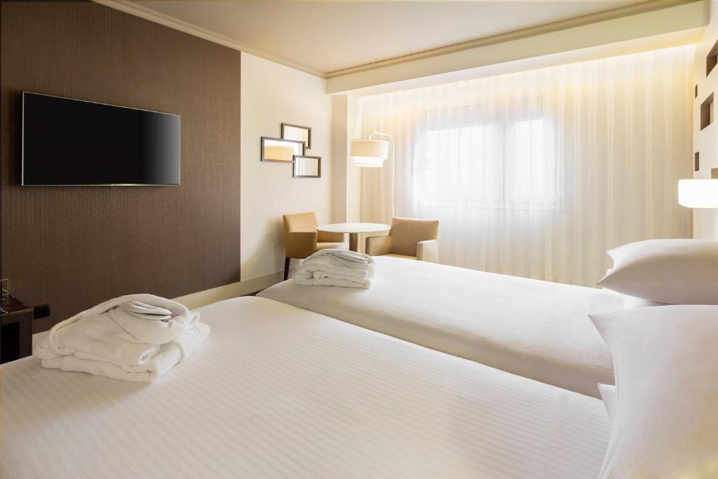 A bed or beds in a room at Madrid Marriott Auditorium Hotel & Conference Center