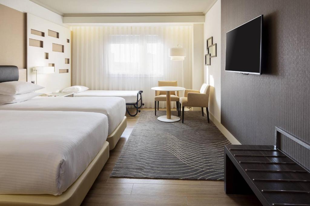 A bed or beds in a room at Madrid Marriott Auditorium Hotel & Conference Center