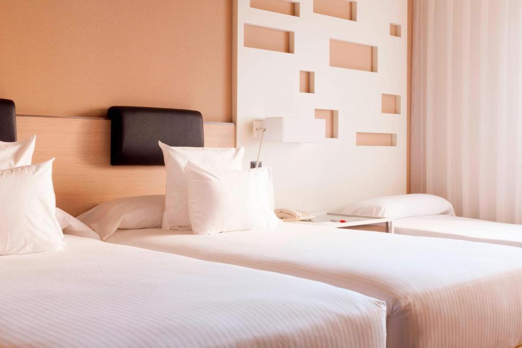 A bed or beds in a room at Madrid Marriott Auditorium Hotel & Conference Center