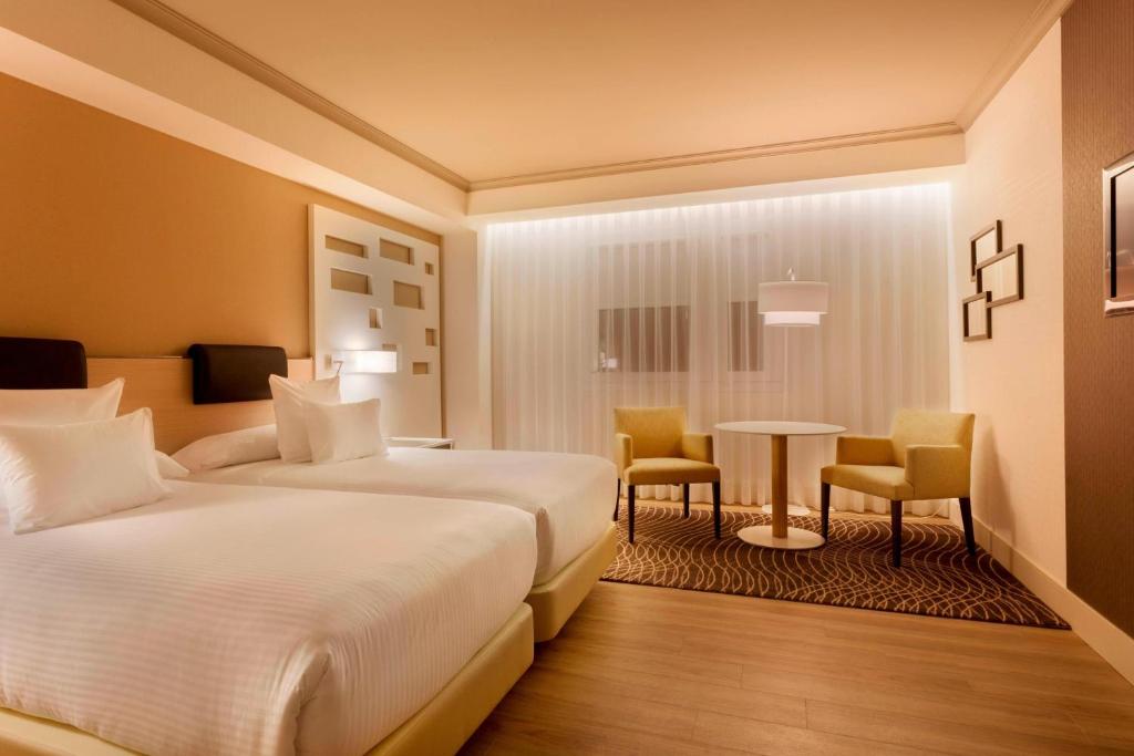 A bed or beds in a room at Madrid Marriott Auditorium Hotel & Conference Center