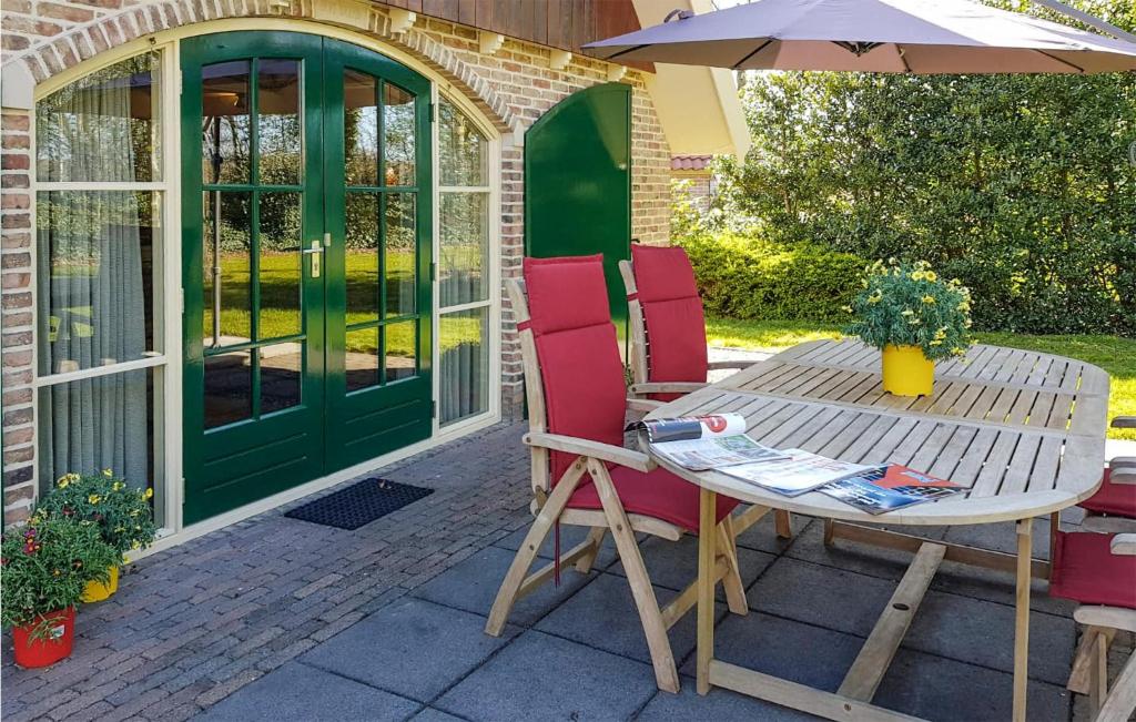 una mesa y sillas con una sombrilla en el patio en Awesome Home In Ijhorst With Kitchen, en IJhorst