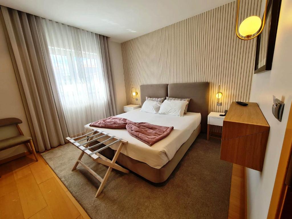 Hotel Albergaria Borges في تشافيس: غرفة فندقية بسرير كبير ونافذة