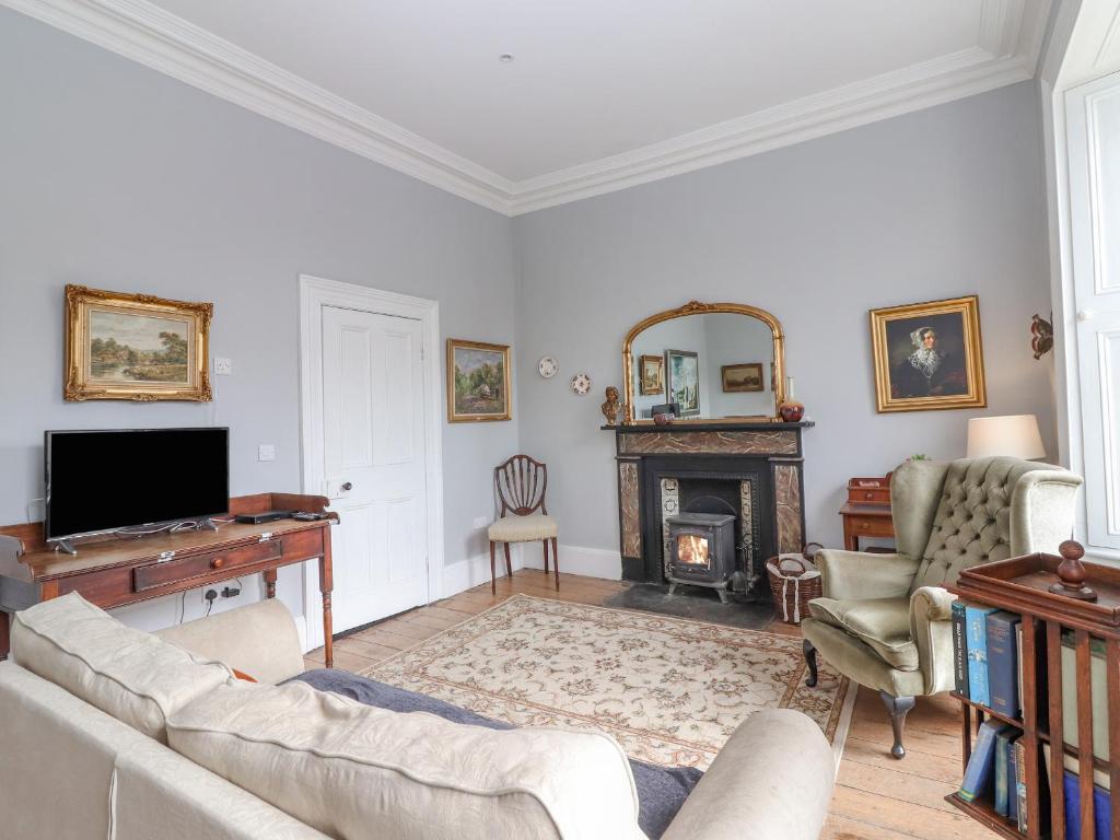 sala de estar con sofá y chimenea en The Merchant's House en Kilrush