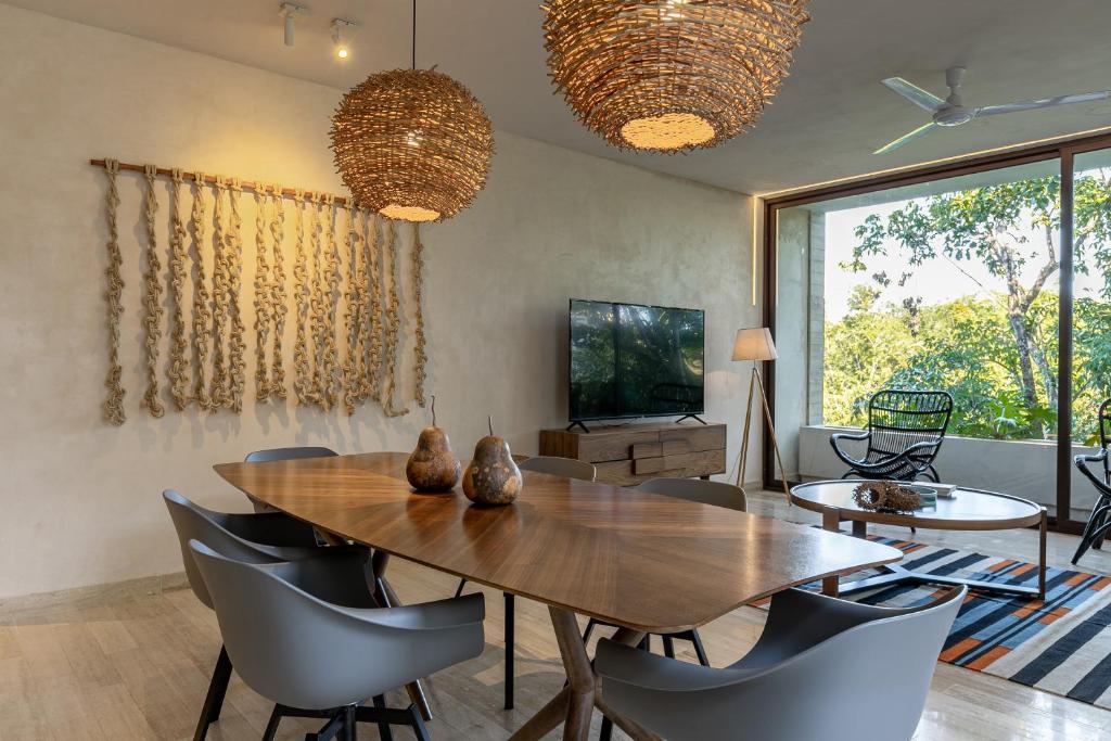 een eetkamer met een houten tafel en stoelen bij 308-303 Beautiful apartments with 3 bedrooms in Tulum