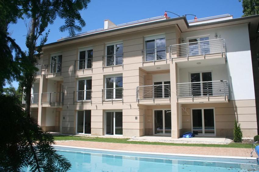 un edificio con piscina frente a él en Zamárdi apartman, en Zamárdi