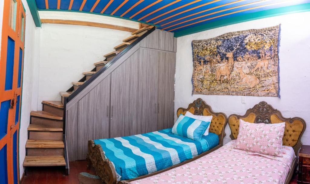 1 dormitorio con 1 cama al lado de una escalera en Misiá Emilia, Café - Hostal en Apía