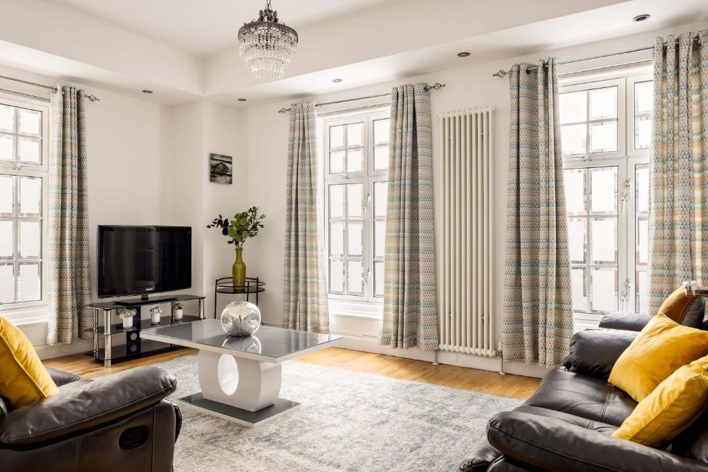 ein Wohnzimmer mit 2 Sofas und einem TV in der Unterkunft Park Street Mayfair apartments in London