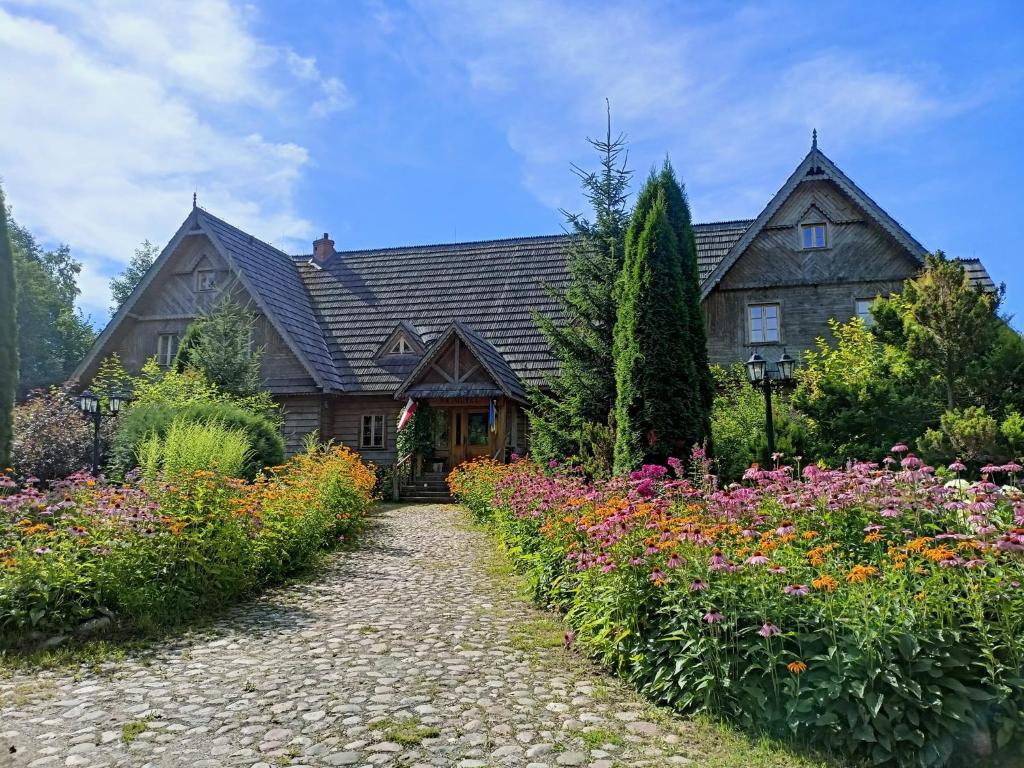 a house with a garden of flowers in front of it at Wejmutka, Białowieża in Białowieża