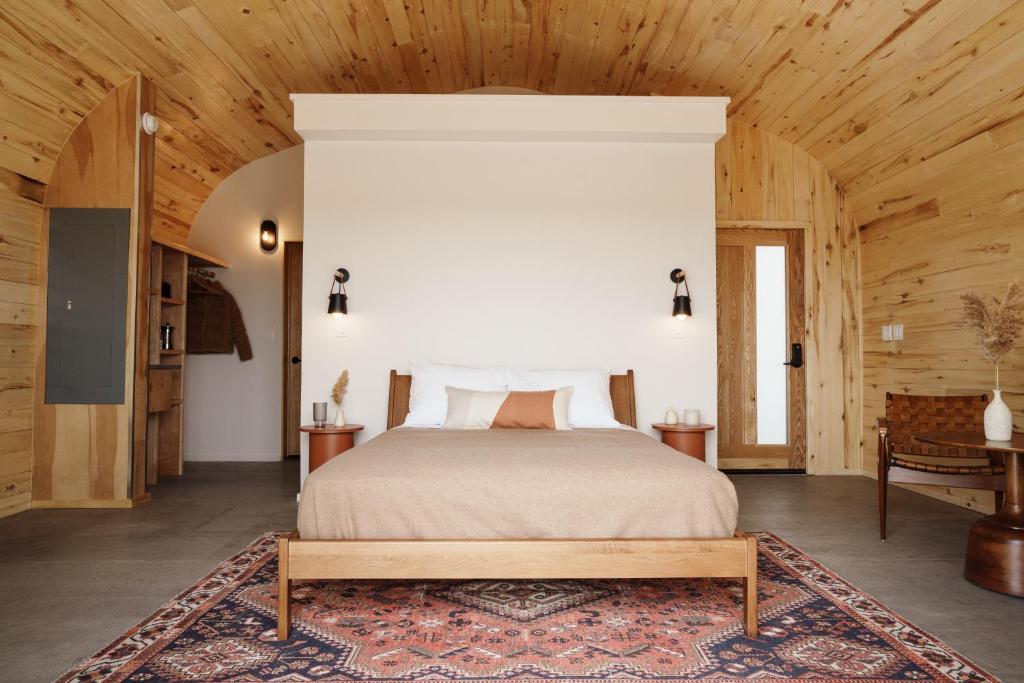 una camera con letto e soffitto in legno di Frontier Drive Inn a Center