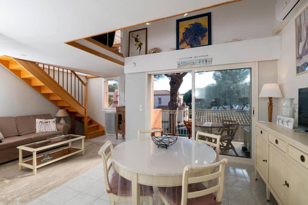 un salon avec une table et un canapé dans l'établissement Charmant duplex à 500 m du port d'hyeres LESCLESDENICOLE LE PRADET, à Hyères