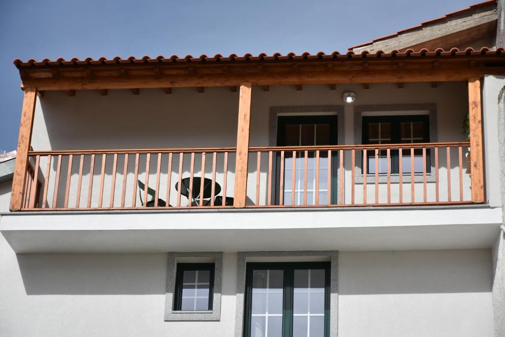 a dog sitting on the balcony of a house at Refúgio Transmontano in Bragança