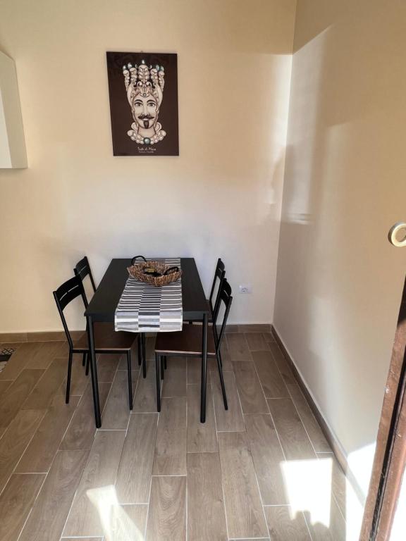 een eetkamer met een zwarte tafel en stoelen bij La dimora di Silvio in Catania