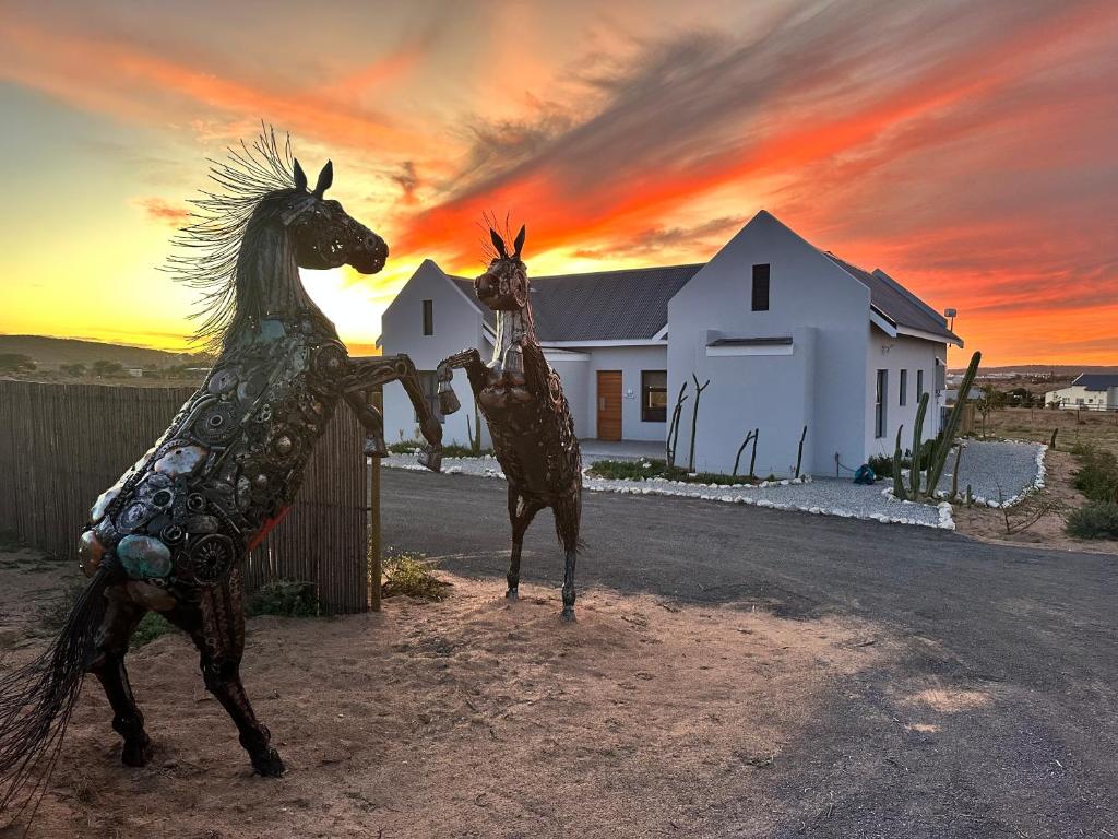 a statue of a horse standing next to a house at Casa Felice in Langebaan