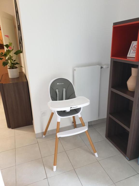 a white chair in a room with a refrigerator at Le Colisée du Plessis-parking gratuit in Le Plessis-Robinson