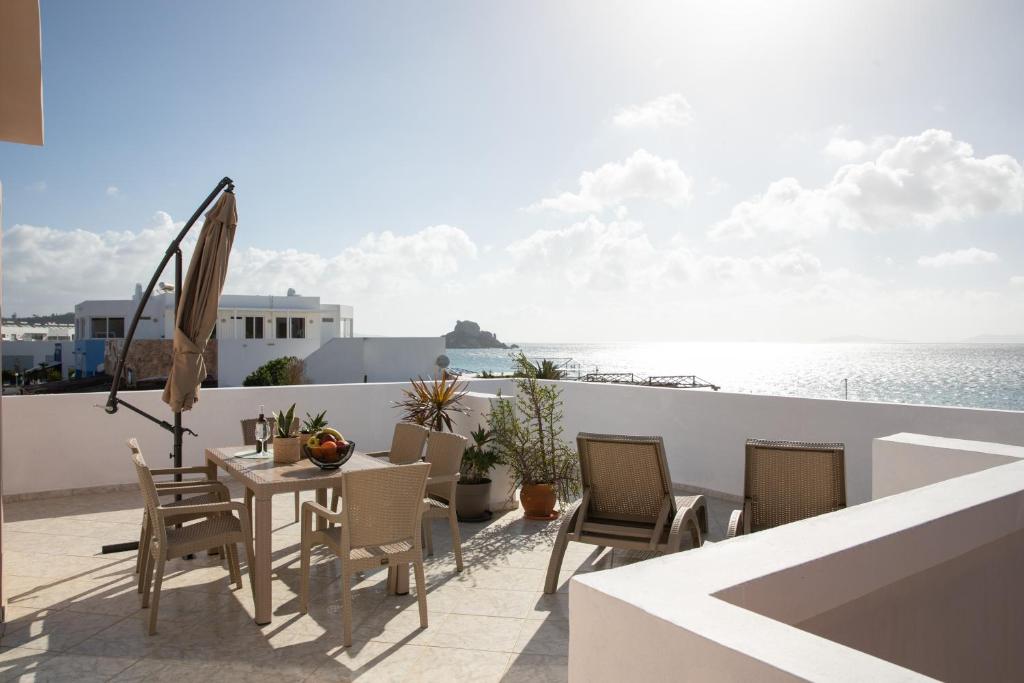 a balcony with a table and chairs and the ocean at Aegean Eyes 3bd House Βy the Sea in Kefalos