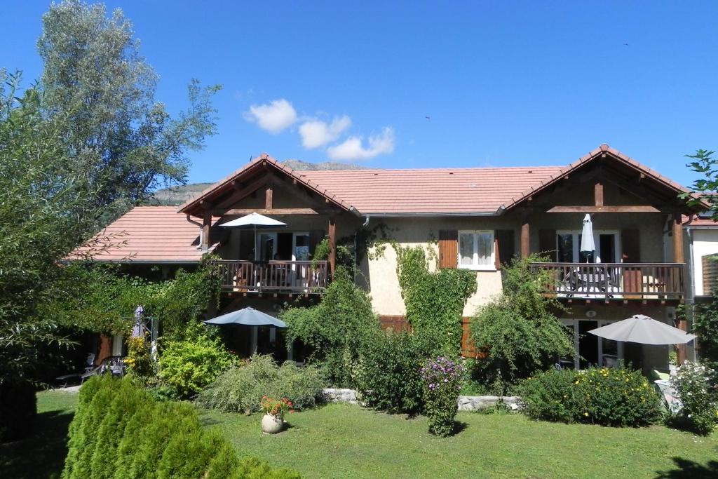 uma casa com uma varanda e um quintal em À la Petite Maison em Gap